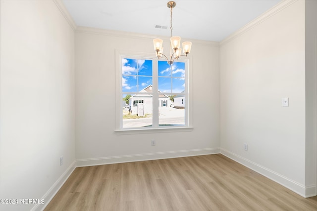 empty room featuring an inviting chandelier, ornamental molding, and light hardwood / wood-style floors