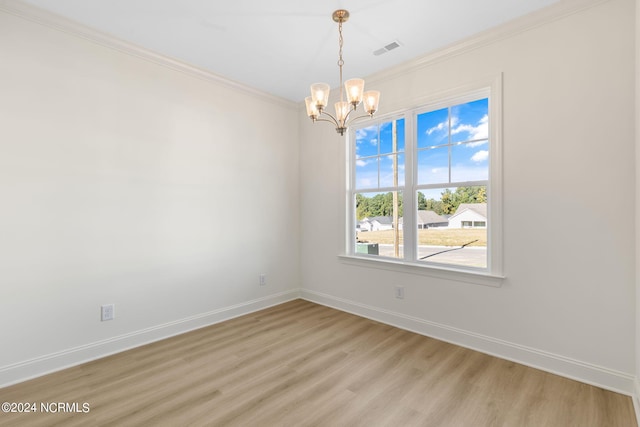 empty room with an inviting chandelier, ornamental molding, and light hardwood / wood-style floors