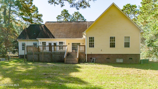 back of property featuring a deck and a lawn