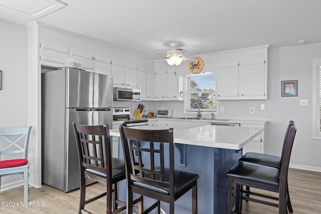 kitchen featuring light hardwood / wood-style flooring, white cabinetry, stainless steel appliances, and ceiling fan