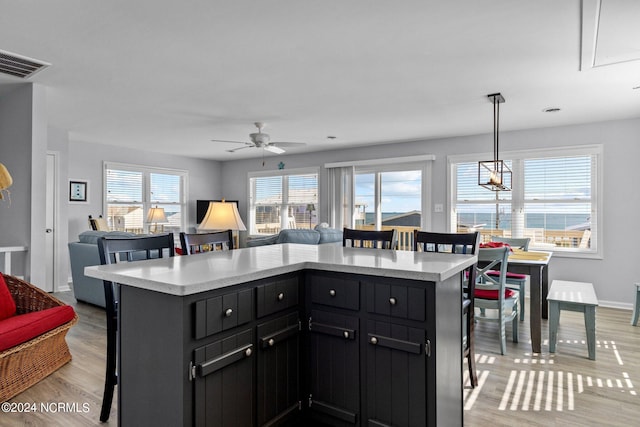 kitchen featuring a breakfast bar, light hardwood / wood-style floors, and a wealth of natural light