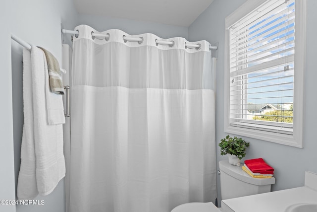 bathroom featuring vanity, toilet, and walk in shower