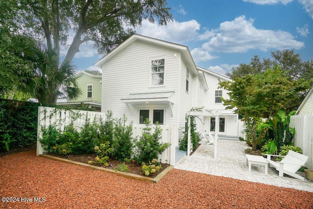 rear view of house featuring a patio, a fenced backyard, and a pergola