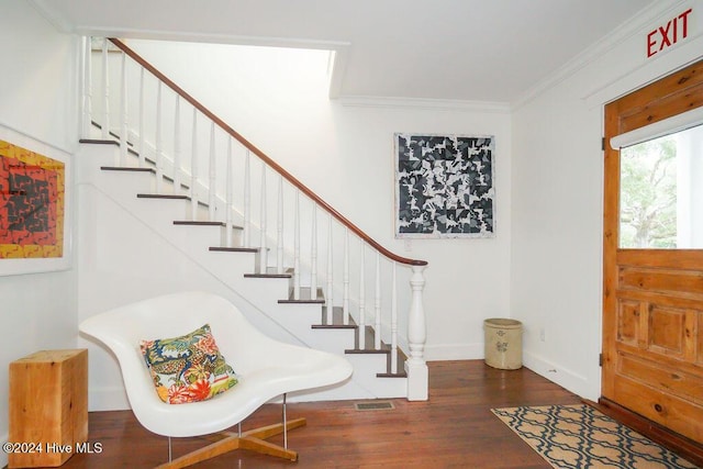 entrance foyer with wood finished floors, crown molding, stairs, and baseboards