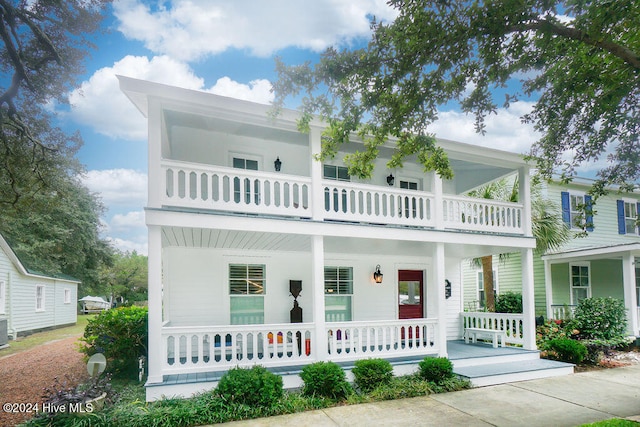 view of front of home with a porch, cooling unit, and a balcony