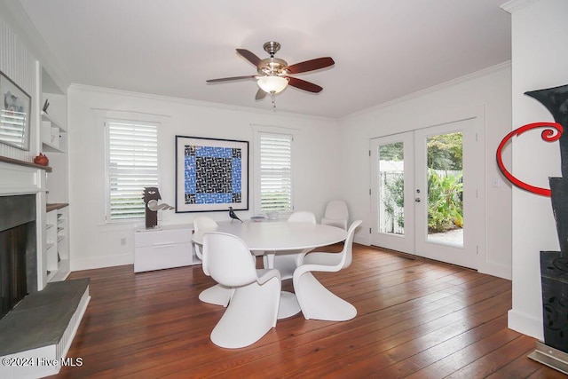dining space with a fireplace with raised hearth, french doors, hardwood / wood-style floors, a ceiling fan, and ornamental molding