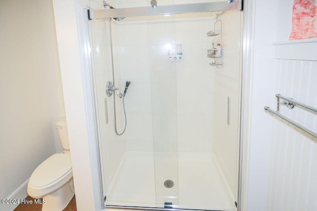 full bath featuring a shower stall and toilet