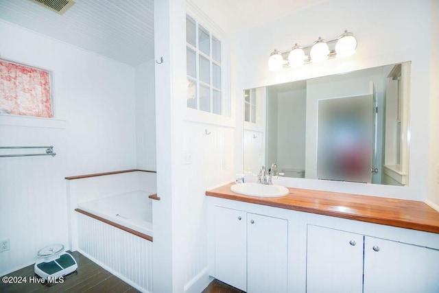 bathroom with vanity and a garden tub
