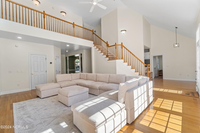 living room with light hardwood / wood-style floors, high vaulted ceiling, and ceiling fan