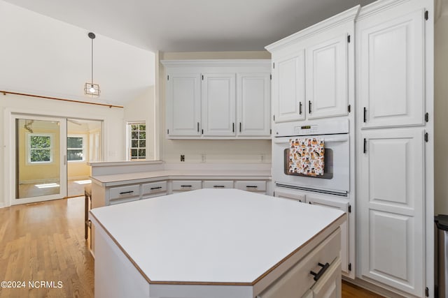 kitchen featuring white oven, white cabinets, and a kitchen island