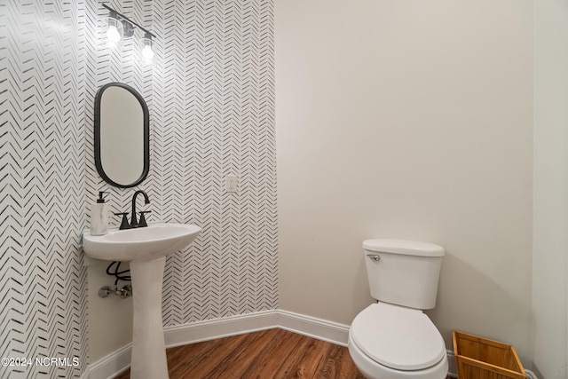 bathroom with toilet and hardwood / wood-style flooring