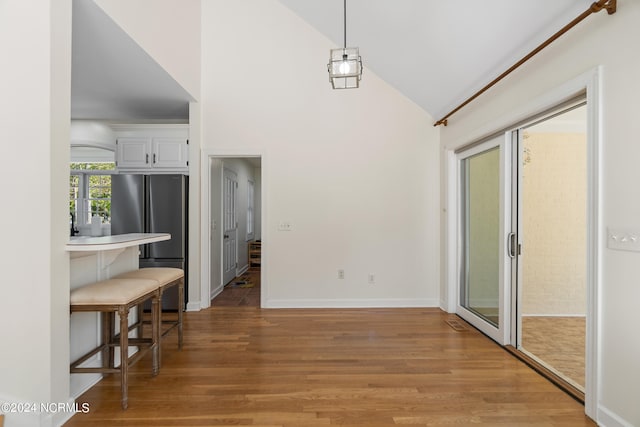 dining space featuring lofted ceiling and light wood-type flooring