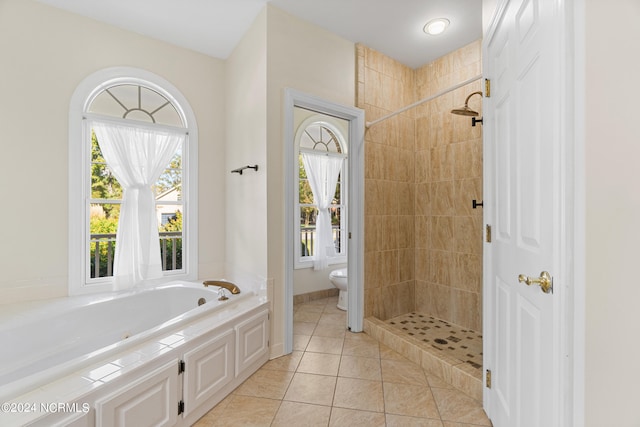 bathroom featuring plus walk in shower, toilet, and tile patterned flooring