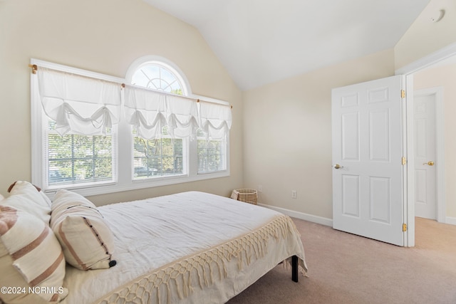 carpeted bedroom with lofted ceiling