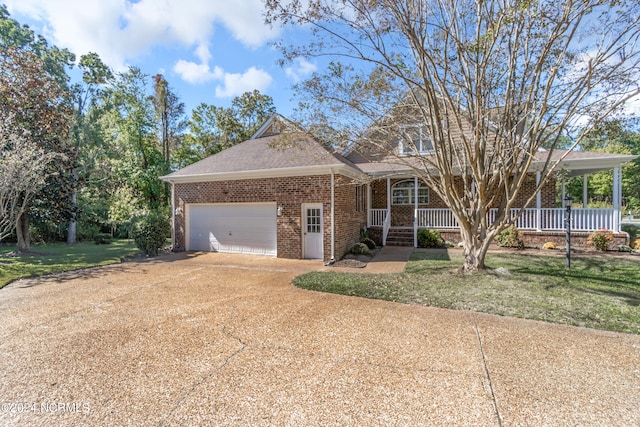 view of front of property featuring covered porch, a garage, and a front lawn