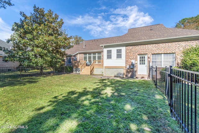 back of property featuring a yard and a deck