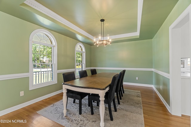 dining room with hardwood / wood-style floors, a chandelier, and a tray ceiling