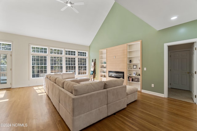 living room with light hardwood / wood-style flooring, high vaulted ceiling, and ceiling fan