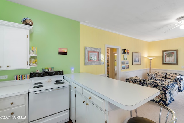 kitchen featuring a kitchen bar, white range with electric cooktop, kitchen peninsula, and white cabinetry