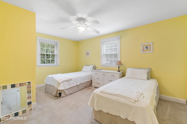 carpeted bedroom featuring ceiling fan and multiple windows