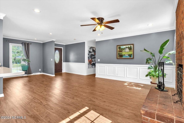 unfurnished living room featuring wood-type flooring, ceiling fan, and ornamental molding