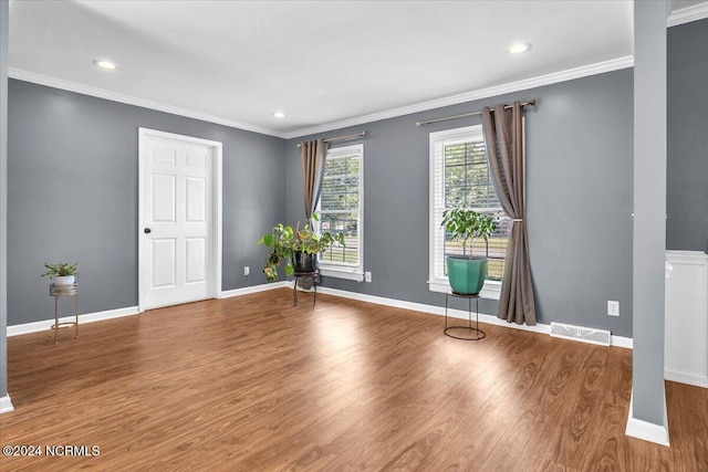 empty room with hardwood / wood-style flooring and ornamental molding