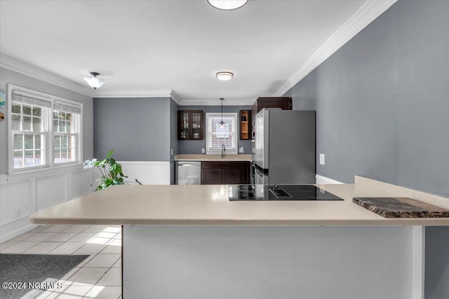 kitchen featuring sink, crown molding, hanging light fixtures, light tile patterned floors, and stainless steel appliances