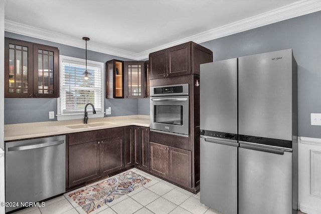 kitchen with sink, ornamental molding, decorative light fixtures, light tile patterned flooring, and stainless steel appliances