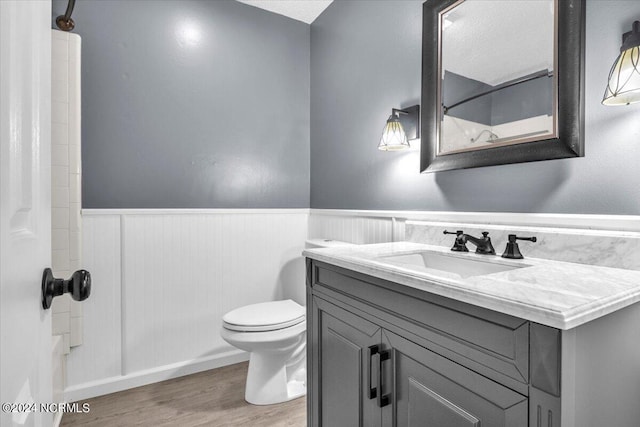 bathroom with hardwood / wood-style flooring, vanity, and toilet