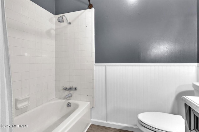 bathroom featuring toilet, wood-type flooring, and tiled shower / bath