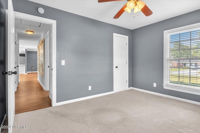 empty room featuring ceiling fan and light colored carpet