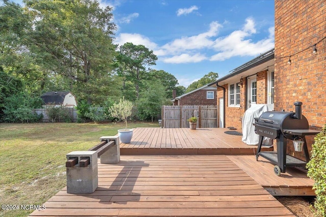 wooden terrace featuring a yard and grilling area