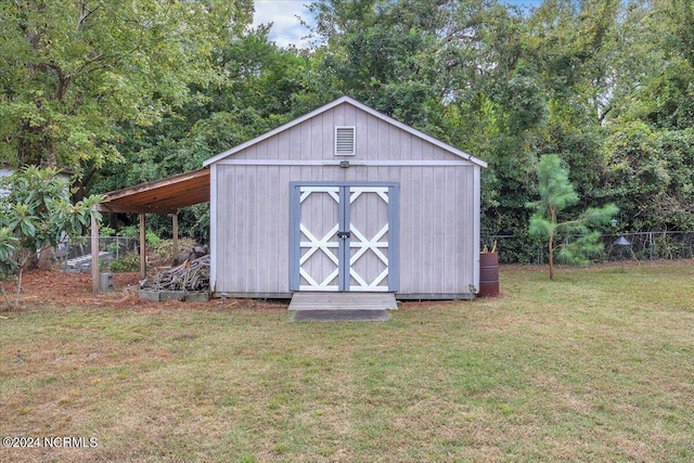 view of outdoor structure featuring a lawn and a carport