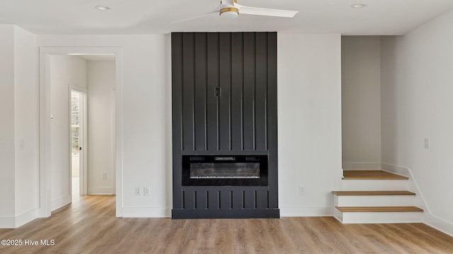 unfurnished living room with a fireplace, ceiling fan, and light hardwood / wood-style floors