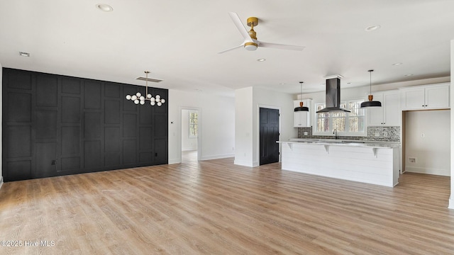 unfurnished living room with light hardwood / wood-style floors and ceiling fan