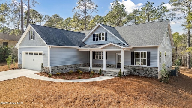 craftsman house with a garage, cooling unit, and a porch