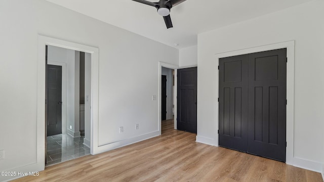 unfurnished bedroom featuring ceiling fan, light hardwood / wood-style flooring, connected bathroom, and a closet