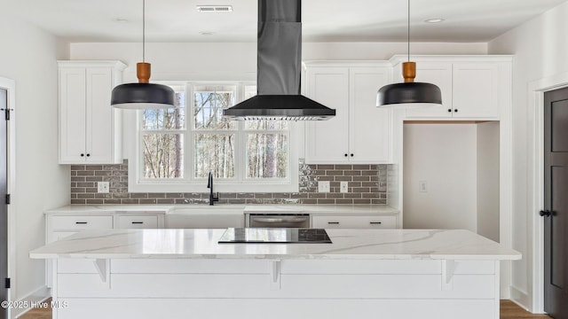 kitchen featuring white cabinetry, pendant lighting, light stone countertops, and island exhaust hood