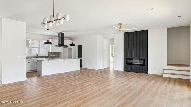 kitchen with a kitchen island, white cabinetry, pendant lighting, and island exhaust hood