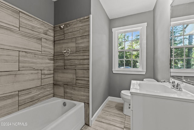 full bathroom with tiled shower / bath, vanity, and toilet