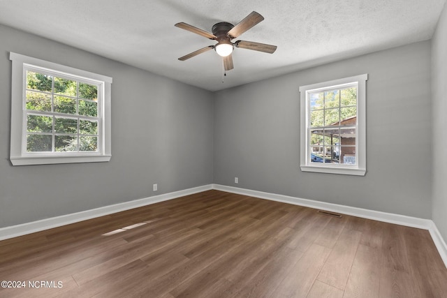 spare room with ceiling fan, a textured ceiling, and dark hardwood / wood-style floors