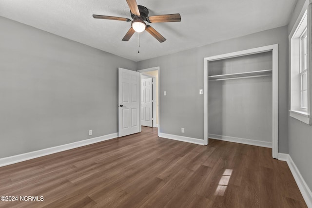 unfurnished bedroom with ceiling fan, a textured ceiling, a closet, and dark wood-type flooring