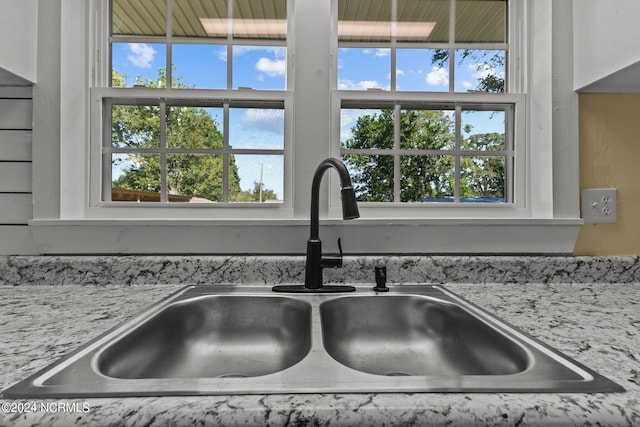 room details featuring light stone countertops and sink