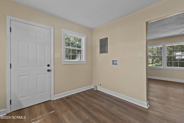 laundry room with dark wood-type flooring, washer hookup, a textured ceiling, and a healthy amount of sunlight