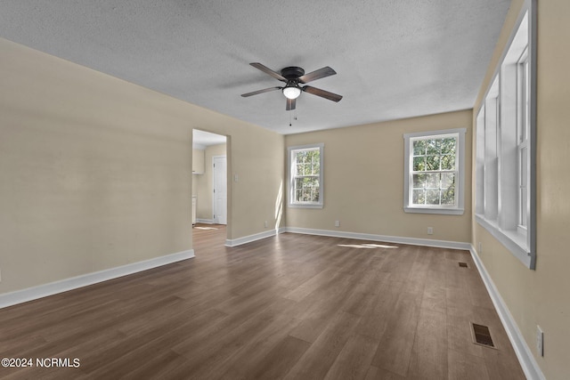 unfurnished room featuring dark wood-type flooring, ceiling fan, and a textured ceiling