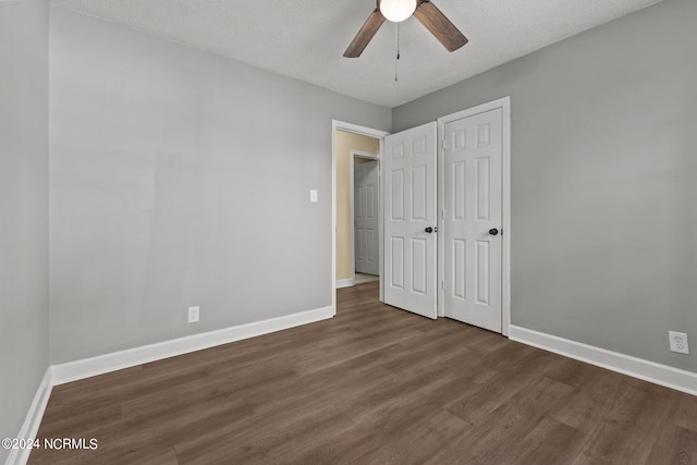 unfurnished bedroom with ceiling fan, dark hardwood / wood-style floors, and a textured ceiling