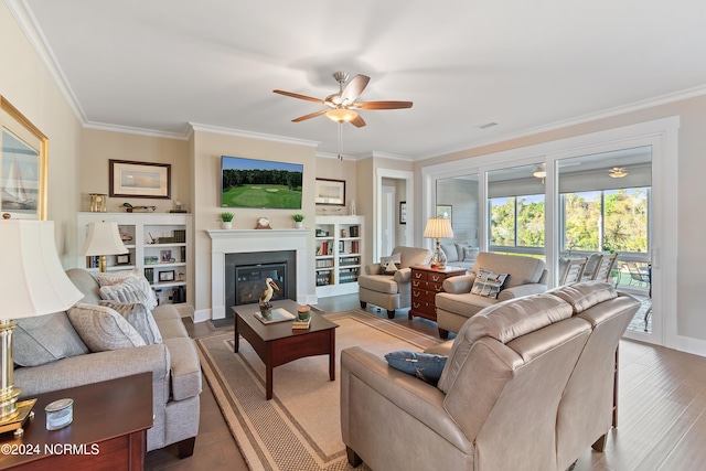 living room featuring hardwood / wood-style floors, ceiling fan, and crown molding