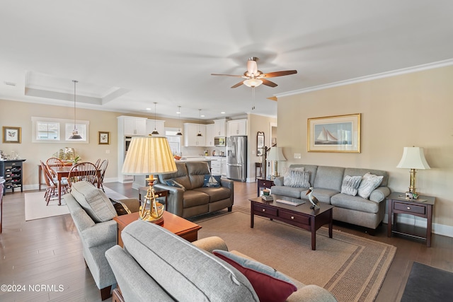 living room featuring dark hardwood / wood-style flooring, ceiling fan, and crown molding