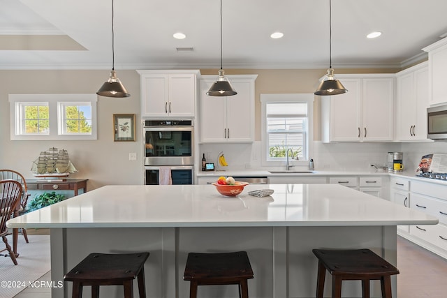 kitchen with hanging light fixtures, sink, a healthy amount of sunlight, and stainless steel appliances