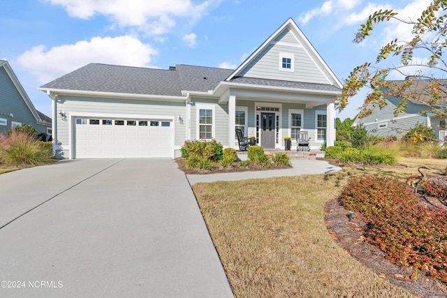 view of front of house with a garage, a front lawn, and a porch